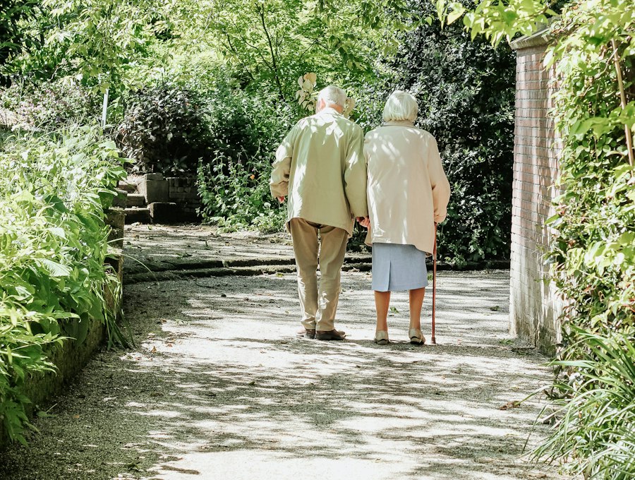 An elderly couple walking together on a garden path
